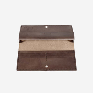 a dark brown leather wallet lying open on a flat surface. The wallet has multiple internal pockets, hand stitching and metal hardware closures.