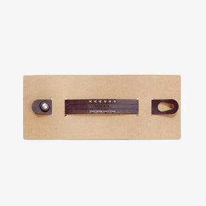 brown card packaging holding and displaying a brown leather wristband with stitch detailing and the word 'HOPE' etched into the leather